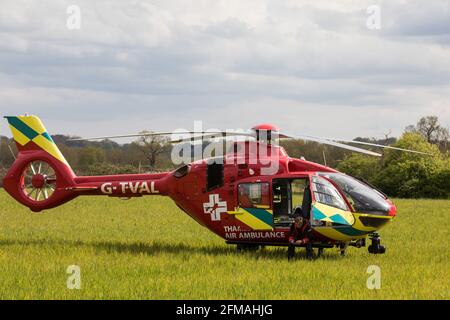 Windsor, UK. 7th May, 2021. The Thames Valley Air Ambulance helicopter is pictured stationary in a field alongside Windsor Great Park. Thames Valley Air Ambulance's Airbus H135, with a maximum speed of 160mph, is able to reach any destination in Berkshire, Buckinghamshire or Oxfordshire within fifteen minutes. Credit: Mark Kerrison/Alamy Live News Stock Photo