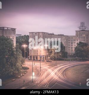 Light trails of the road traffic on Berlin's Strausberger Platz at night. Stock Photo