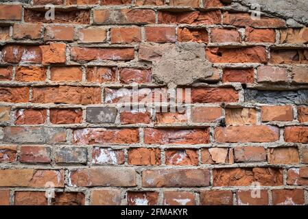 building wall facade of an old house made of cracked red brick. Background for design or web page. Stock Photo