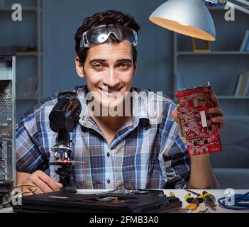 The repairman trying to repair laptop with miscroscope Stock Photo