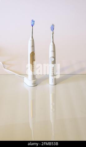 Two Sonicare Toothbrushes on Glass Countertop Stock Photo