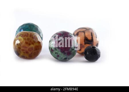 Different natural stone beads on a white background,Quartz agate stone beads,Many bracelets made of various natural stones,balls of natural mineral ge Stock Photo