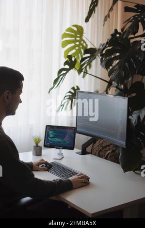 Young developer work with curved screen and tablet.Freelancer is working at home Stock Photo