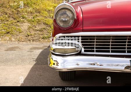 A Close Up of an Old Car Grille, Bumper, and Headlight Stock Photo