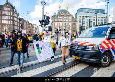 Amsterdam, Netherlands. 07th May, 2021. Protesters walk past a police van during the demonstration. Tens of thousands of Colombians have joined protests in the country's major cities against a proposed tax reform. More than 800 people are reported to have been injured during the clashes between the police and demonstrators. In The Netherlands, the Colombian community gathered at the Dam Square, in the center of Amsterdam to show their support with the people in Colombia, and to make it possible for people to know what is happening in their country. From the Dam, they marched to protest in fron Stock Photo