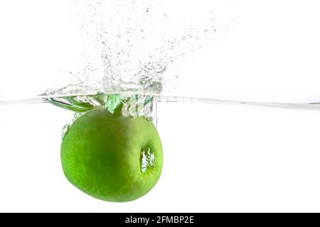 juicy green apple falls into the water on a white background, place under the text Stock Photo