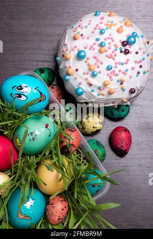 Easter cake and red yellow green and blue eggs lie on the background Stock Photo