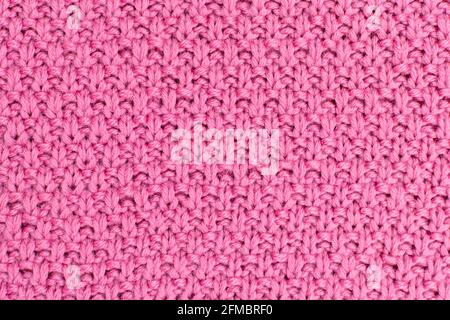 Pink knitted fabric pearl woolen background. The structure of the fabric with a natural texture. Fabric background. Knitted woolen background. Stock Photo