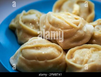 delicious manti lie on a blue plate Stock Photo