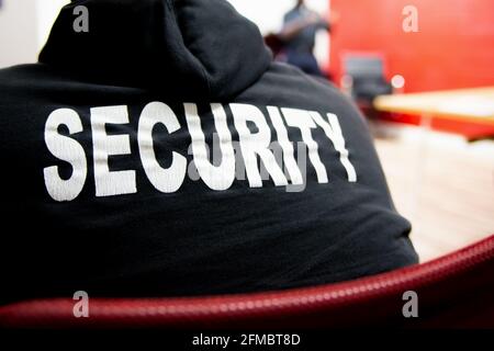 Security guard in black hood and uniform in a strategy meeting. Stock Photo