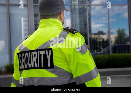 Tall security guard in a uniform patrolling condo area. Stock Photo