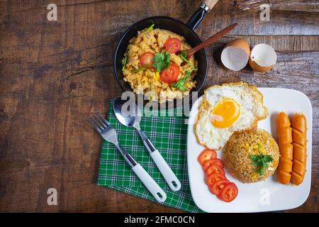 Cook American fried rice in a pan, served with fried eggs and sausages. Stock Photo