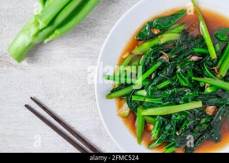 Fried Kale with Oyster Sauce menu on wooden table Stock Photo