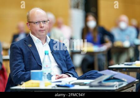 Schleswig, Germany. 08th May, 2021. Stefan Seidler (SSW, 41), candidate for list position 1 of his party, sits among the delegates during the extraordinary state party conference for the top candidacy for the Bundestag election at the A. P. Moeller School. Credit: Axel Heimken/dpa/Alamy Live News Stock Photo