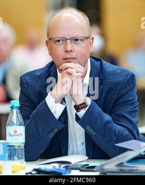 Schleswig, Germany. 08th May, 2021. Stefan Seidler (SSW, 41), candidate for list position 1 of his party, sits among the delegates during the extraordinary state party conference for the top candidacy for the Bundestag election at the A. P. Moeller School. Credit: Axel Heimken/dpa/Alamy Live News Stock Photo