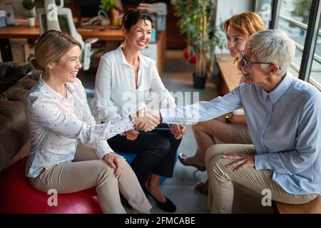 A young female office worker at her new job is getting know with group of female colleagues while taking a break in a friendly atmosphere at workplace Stock Photo