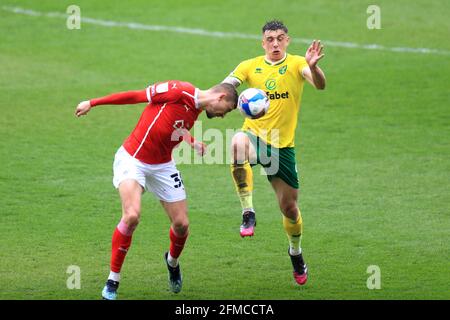 Norwich City's Jordan Hugill (right) and Barnsley's Michal Helik battle for the ball during the Sky Bet Championship match at Oakwell Stadium, Barnsley. Picture date: Saturday May 8, 2021. Stock Photo