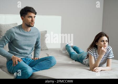 Blue jeans sweaters and a bra lying on a bed Stock Photo - Alamy