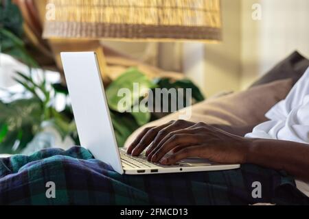 view shot of african male hands busy working on aptop sitting at home. Stock Photo