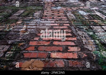 Grungy old brick wall with flaking and peeling paint from low perspective looking up Stock Photo