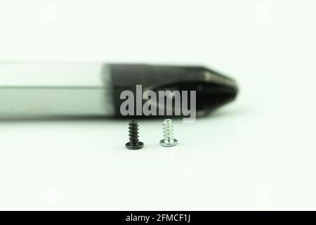 Small screws on a large screwdriver, the opposite concept. Different thinking, independent thinker concept. Background with request for text Stock Photo