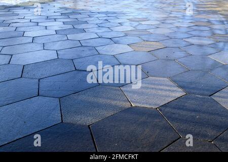 Pavement tiles in the form of hexagonal rhombuses, illuminated by the sun Stock Photo