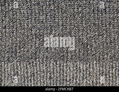 A flat section of knitted grey and white cotton including a border hem Stock Photo