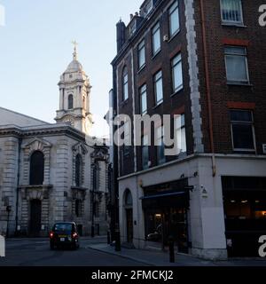 London, Greater London, England - May 04 2021: Taxi stops at a junction on Maddox Street in the evening outside of St George's Church Stock Photo