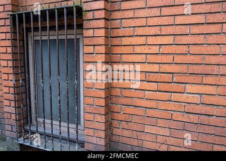 Brick building with steel bars in windows Stock Photo - Alamy