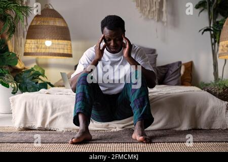 African young man with a depressed expression having terrible headache Stock Photo