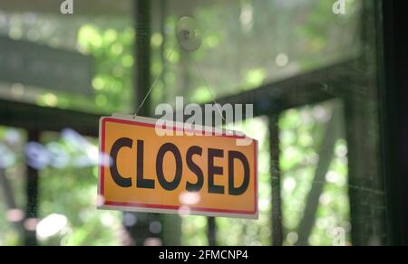 Closed signboard hanging on glass door of a restaurant. Copy space. Stock Photo