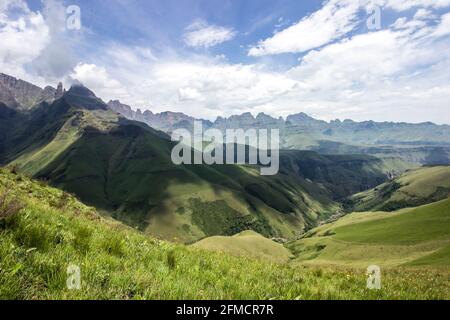 The gathering clouds, throwing shadows over a river valley, surrounded by the jagged peaks of the Drakensberg mountains of South Africa Stock Photo