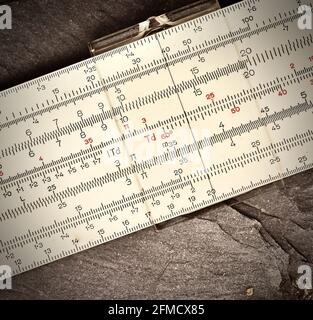 Close up of old slide rule agains rock background Stock Photo