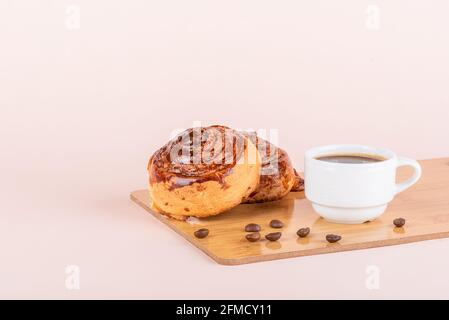 Two sweet cinnamon rolls and a cup of coffee. Homemade buns. Stock Photo