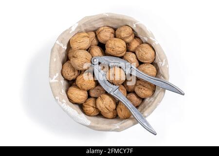 basket with whole walnuts and nutcracker, top view. isolate on white background Stock Photo