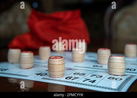 Lotto game. Wooden lotto barrels and card for a game in lotto on a gray background. Board game lotto or bingo. Stock Photo
