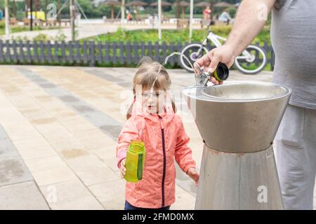 Father dad pours hot coffee tea from thermos into the mug on a family  picnic in the mountains. Child school boy kid is watching his dad filling  the Stock Photo - Alamy