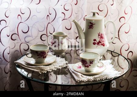 Tea set for two on a small glass table Stock Photo