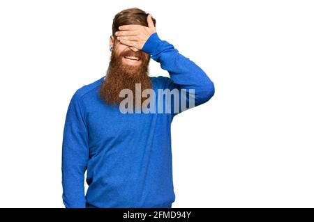 Young irish redhead man wearing casual clothes smiling and laughing with hand on face covering eyes for surprise. blind concept. Stock Photo