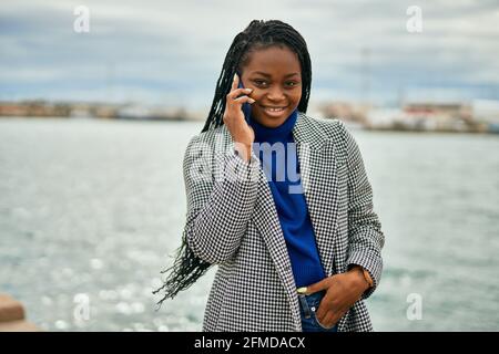 Young african american businesswoman smiling happy talking on the smartphone at the port. Stock Photo
