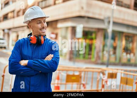 Young caucasian worker smiling happy wearing uniform at the city. Stock Photo