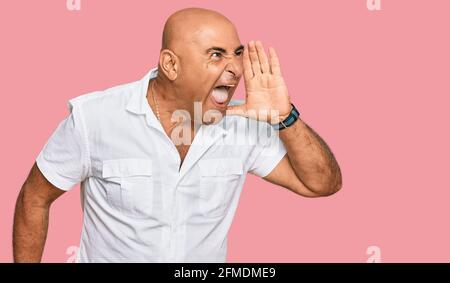Mature middle east man with mustache wearing casual white shirt shouting and screaming loud to side with hand on mouth. communication concept. Stock Photo