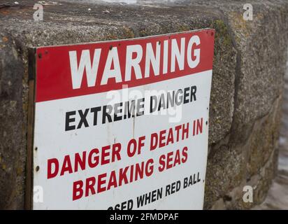 Porthleven,Cornwall,8th May 2021,A warning sign on the sea wall warns people of the extreme danger of Death caused by breaking seas in Porthleven, Cornwall. The Temperature was 12C and the forecast is for rain & strong winds over the next few days.Credit: Keith Larby/Alamy Live News Stock Photo