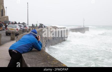 Porthleven,Cornwall,8th May 2021,A man takes photos of the rough sea and large waves  caused by the extremely strong winds in Porthleven, Cornwall. The Temperature was 12C, the forecast is for rain & strong winds over the next few days.Credit: Keith Larby/Alamy Live News Stock Photo
