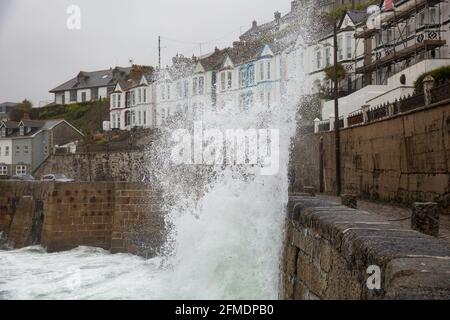 Porthleven,Cornwall,8th May 2021,Waves crash over the harbour wall  in Porthleven, Cornwall. The Temperature was 12C and the forecast is for rain & strong winds over the next few days.Credit: Keith Larby/Alamy Live News Stock Photo