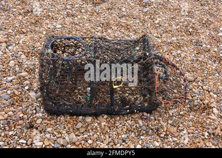 View of lobster trap on the shingle beach Stock Photo