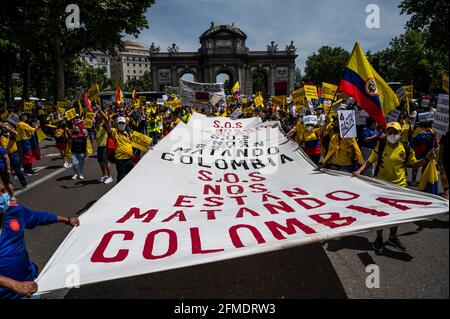 Madrid, Spain. 08th May, 2021. Protesters carrying Colombian flags and a large banner with the words 'S.O.S. They are killing us Colombia', during a demonstration in support of Colombian people and against violence in their homeland. With a balance of dozens of deaths and hundreds injured due to police charges, during demonstrations in Colombia against the tax reform of the Government of Ivan Duque, Colombians residents in Madrid have taken to the streets to protest against President Ivan Duque and demanding the end of violence. Credit: Marcos del Mazo/Alamy Live News Stock Photo