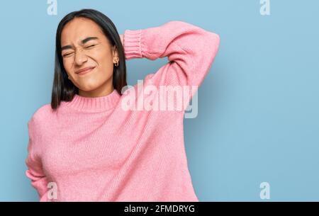 Young asian woman wearing casual winter sweater stretching back, tired and relaxed, sleepy and yawning for early morning Stock Photo