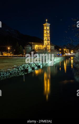 St. Moritz, Switzerland - November 26, 2020: Illuminated catholic church St. Mauritius in the blue hour and its reflection in the lake Stock Photo