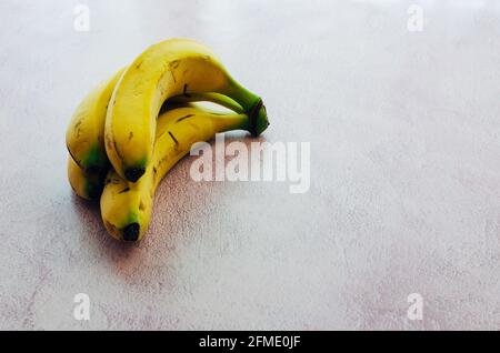 Cluster of bananas on pink textured background Stock Photo